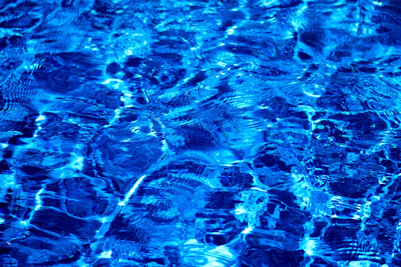 Dynamic and vibrant ripples on a blue water surface, showcasing light and texture.